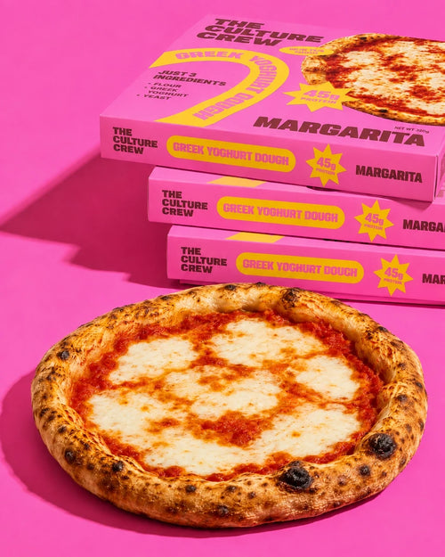 Three Margarita packs stacked behind a cooked Margarita pizza